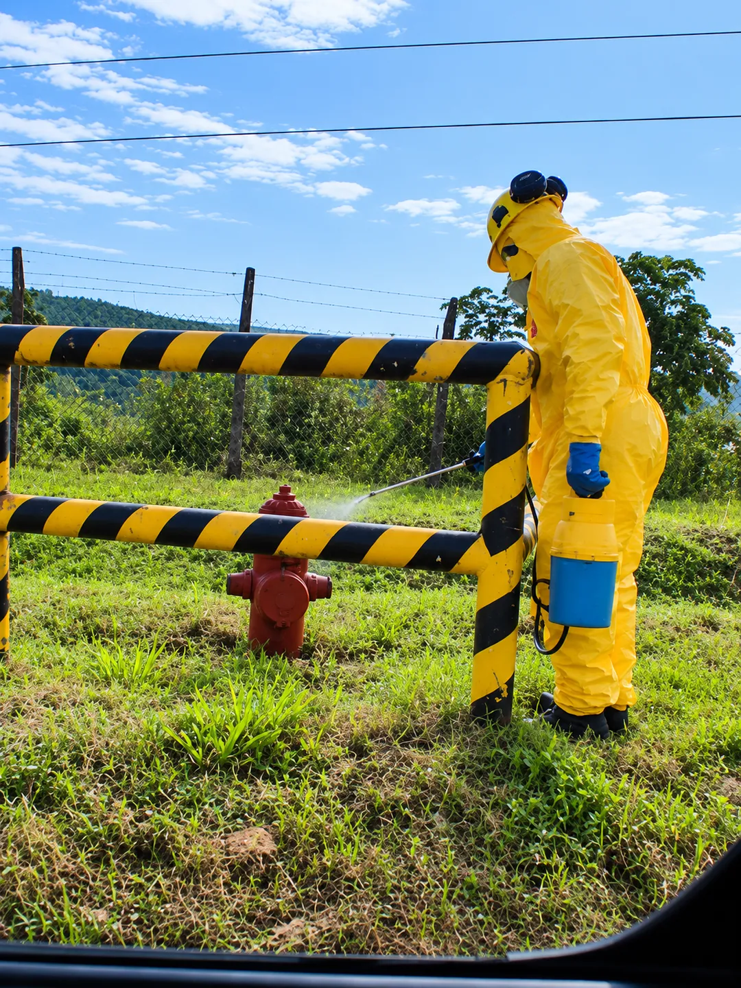 Operario con equipo de protección durante un trabajo de fumigación en un espacio exterior